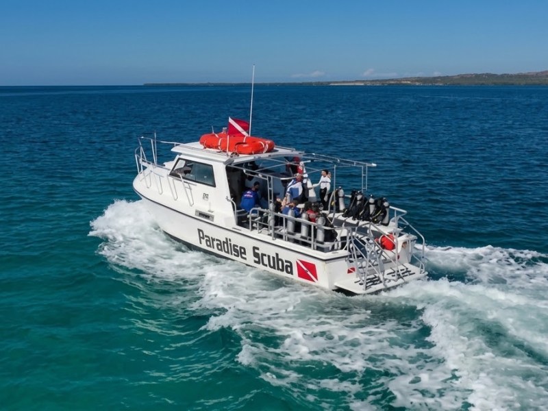 Boat with scuba equipment and passengers on blue ocean water.